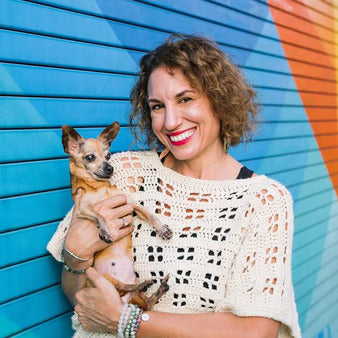 Sara Pai, author of Coco The Miracle Rescue Dog, smiling as she gently holds a senior rescue dog in her arms. This heartwarming moment highlights her dedication to animal rescue, senior pet care, and giving dogs a second chance at a loving home.