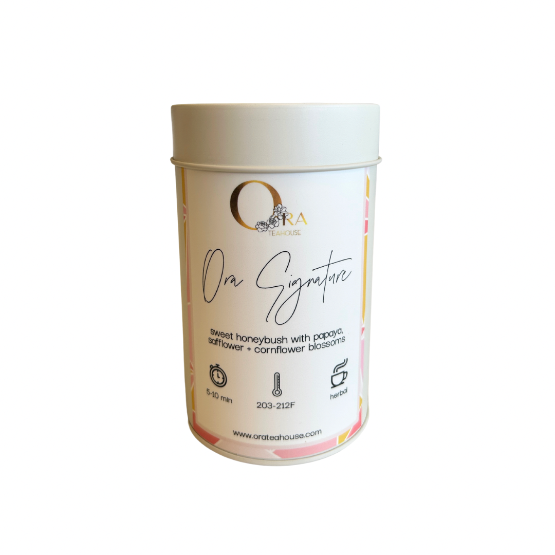 a Signature Tea Blend Tin from Ora Tea House, a naturally sweet South African honeybush tea with safflower, papaya, and cornflower blossoms. This caffeine-free loose-leaf tea offers rich honey and exotic fruit flavors, perfect for a soothing and aromatic tea experience.