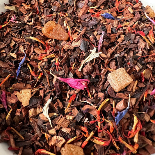 Close-up of Ora Signature Tea Blend from Ora Tea House, featuring a vibrant mix of South African honeybush, safflower, papaya, and cornflower blossoms. The rich textures and natural ingredients are beautifully displayed, highlighting the tea’s aromatic and flavorful blend.